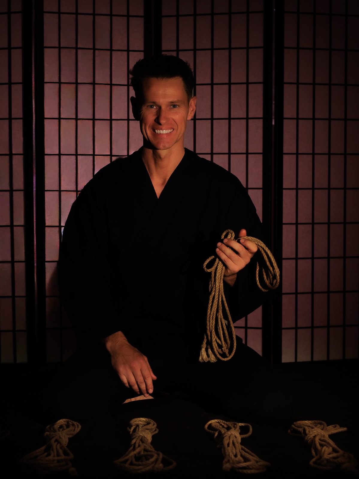 Shibari Practitioner die de ontvanger ondersteunt in ontspanning en lichaamsbewustzijn tijdens de binding